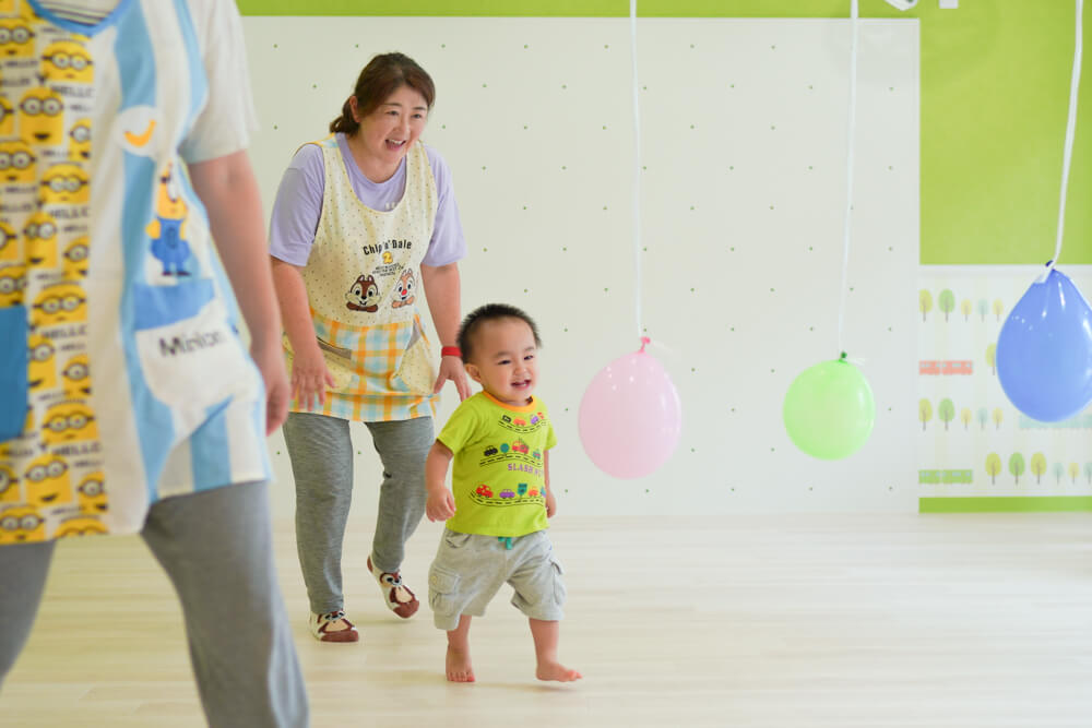 教室内を歩く男の子と先生