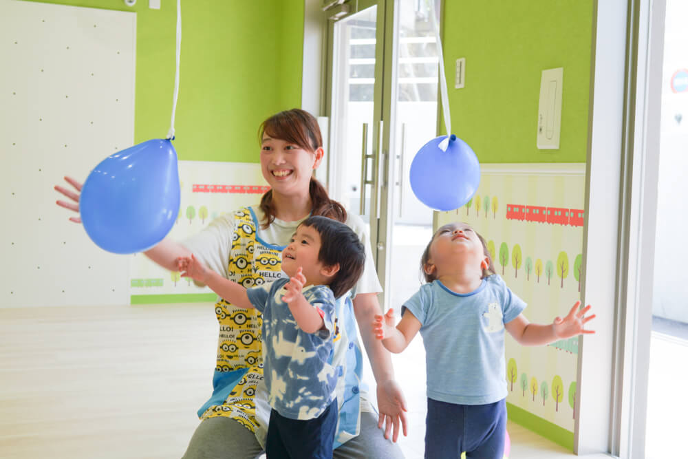 風船で遊ぶ子どもたちと先生